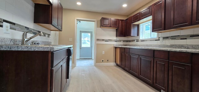 kitchen with a sink, light wood-type flooring, recessed lighting, and backsplash