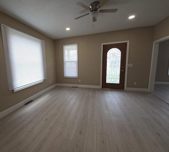 entrance foyer featuring ceiling fan, visible vents, a healthy amount of sunlight, and baseboards