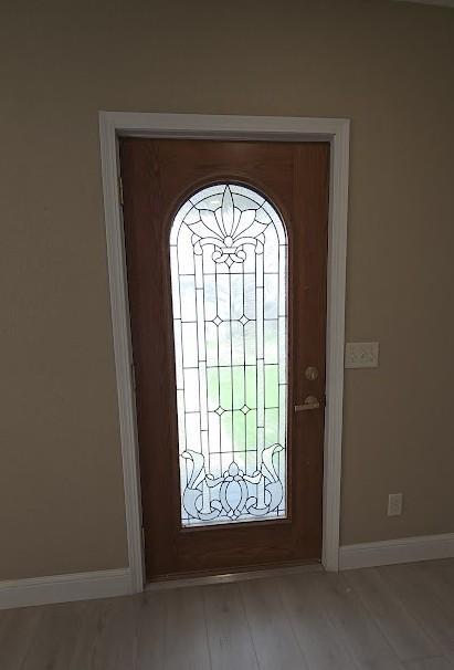 foyer featuring wood finished floors and baseboards