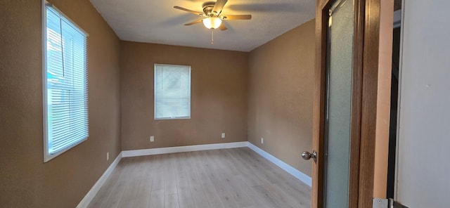 spare room with a ceiling fan, baseboards, and light wood-type flooring