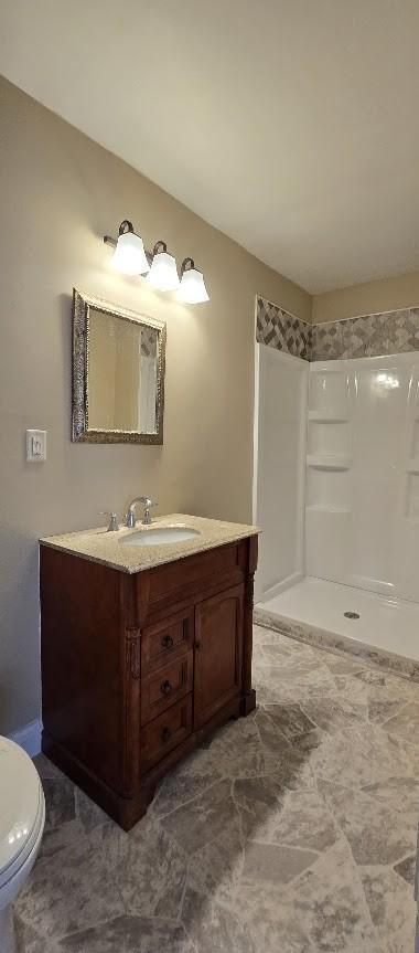 bathroom with a walk in shower, toilet, and vanity