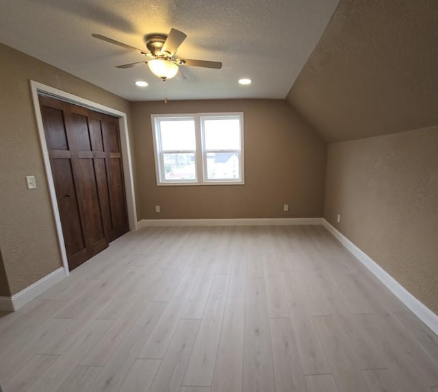 unfurnished bedroom featuring a textured ceiling, light wood-type flooring, and a closet