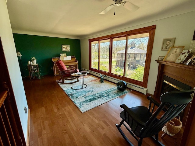 3225 180th St, Lester Prairie, MN 55354 - living area with a ceiling fan, baseboards, a baseboard heating unit, and wood finished floors