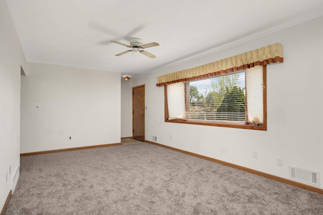 carpeted empty room featuring a ceiling fan and baseboards