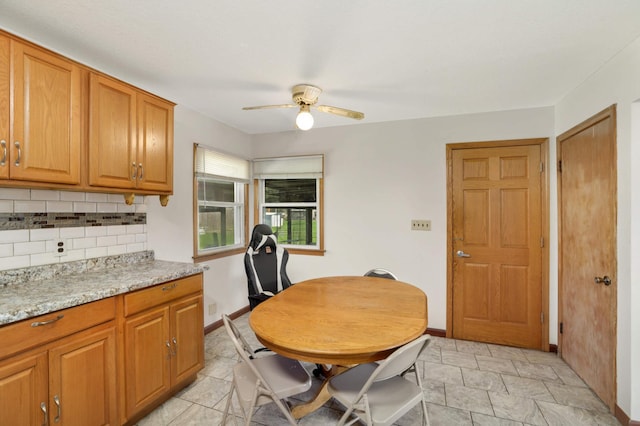 dining space featuring ceiling fan and baseboards