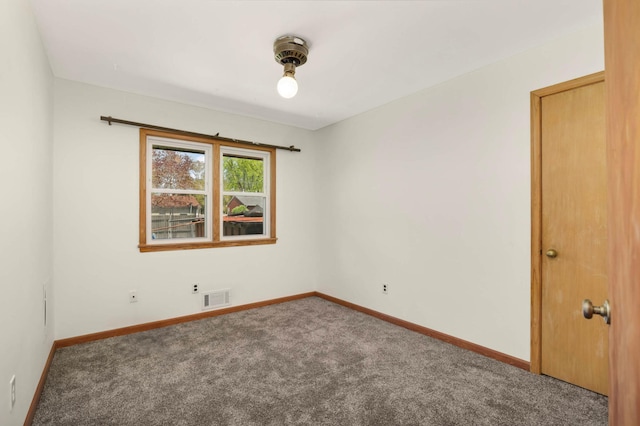 unfurnished room featuring carpet and baseboards