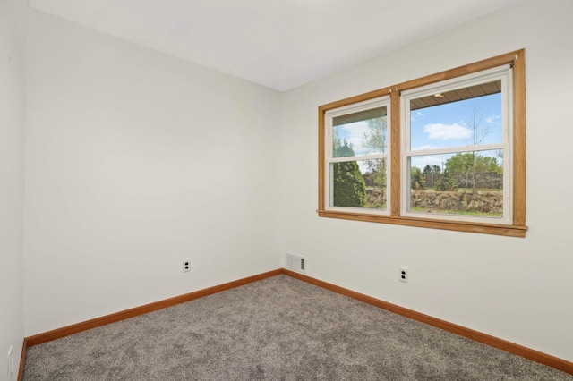 empty room featuring carpet flooring and baseboards
