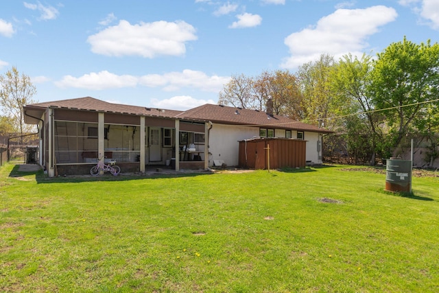 rear view of house with a sunroom and a lawn