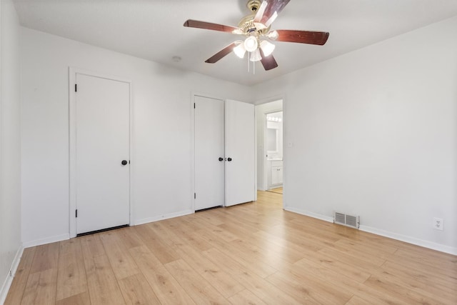 6715 Bloomington Ave, Richfield, MN 55423 - unfurnished bedroom with visible vents, two closets, baseboards, a ceiling fan, and light wood-style flooring