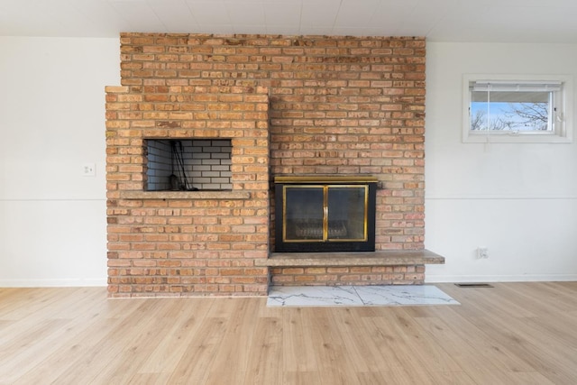 6715 Bloomington Ave, Richfield, MN 55423 - details with baseboards, a fireplace, wood finished floors, and visible vents