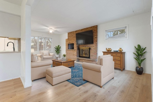 6715 Bloomington Ave, Richfield, MN 55423 - living room with baseboards, a ceiling fan, a brick fireplace, and light wood-type flooring