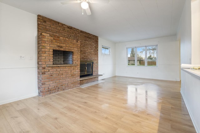 6715 Bloomington Ave, Richfield, MN 55423 - unfurnished living room with a ceiling fan, light wood-type flooring, and a brick fireplace
