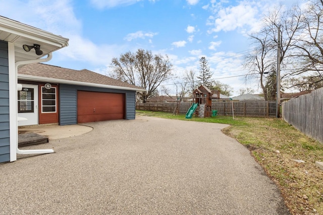 6715 Bloomington Ave, Richfield, MN 55423 - fenced backyard featuring a playground, asphalt driveway, and an attached garage