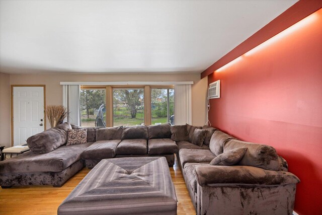 living room with an AC wall unit and light wood-type flooring