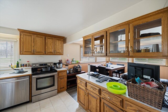 kitchen featuring light countertops, appliances with stainless steel finishes, and brown cabinets