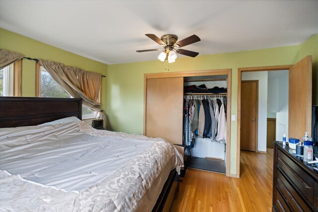 bedroom with light wood-style floors, ceiling fan, and a closet