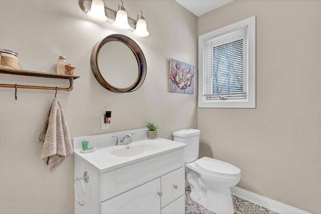 half bath featuring vanity, baseboards, and toilet
