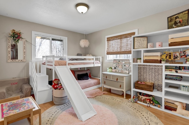 bedroom featuring multiple windows and wood finished floors