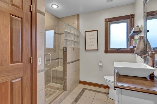 full bathroom with a stall shower, vanity, baseboards, tile patterned floors, and toilet