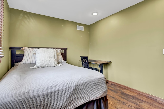 bedroom featuring visible vents and wood finished floors