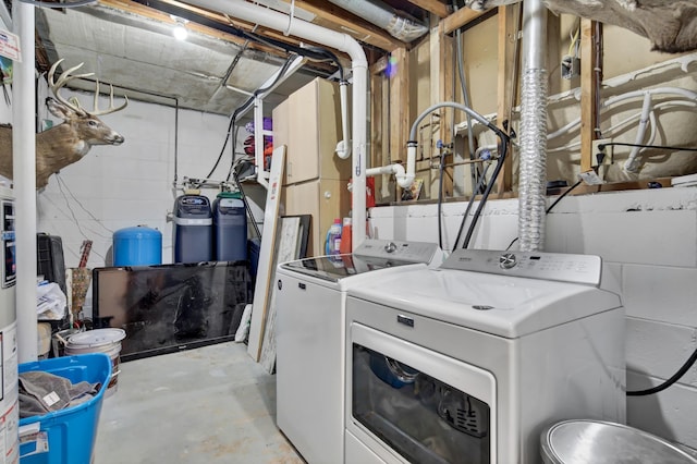laundry area featuring laundry area, washing machine and dryer, and concrete block wall
