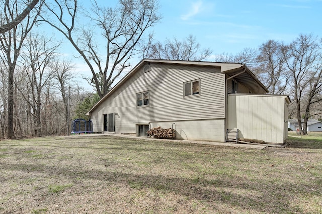 view of property exterior with a lawn and a trampoline