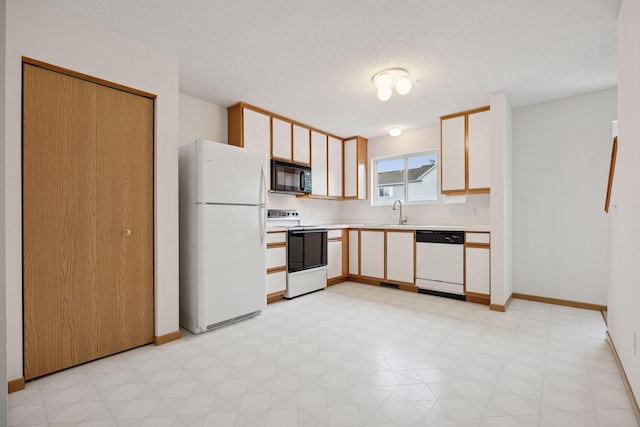 9110 Terra Verde Trl, Eden Prairie, MN 55347 - kitchen with white appliances, light countertops, a sink, baseboards, and a textured ceiling