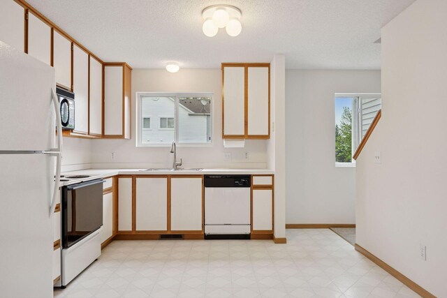 9110 Terra Verde Trl, Eden Prairie, MN 55347 - kitchen featuring white appliances, a sink, light countertops, light floors, and a textured ceiling