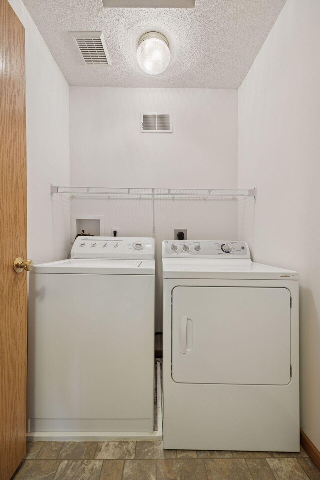9110 Terra Verde Trl, Eden Prairie, MN 55347 - laundry area with separate washer and dryer, stone finish floors, a textured ceiling, and baseboards