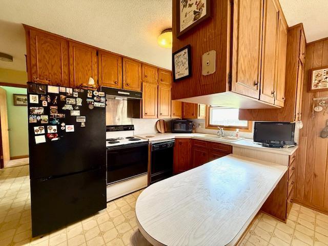 15497 Meiners Rd, Mayville Twp, MN 55921 - kitchen featuring black appliances, a sink, light flooring, under cabinet range hood, and brown cabinets