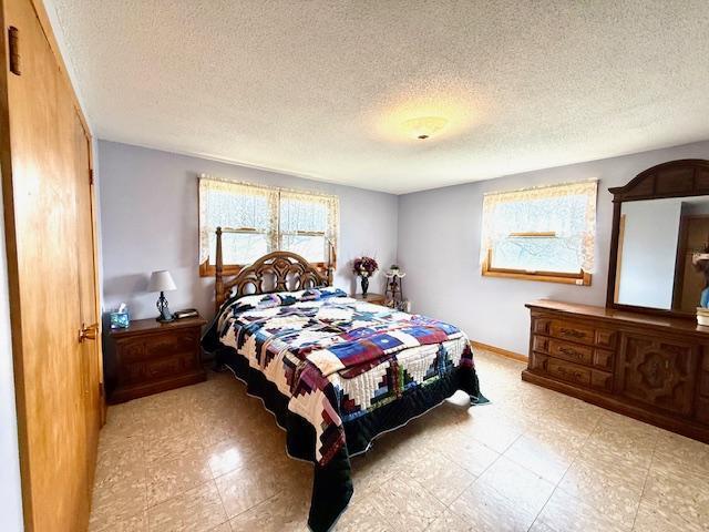 15497 Meiners Rd, Mayville Twp, MN 55921 - bedroom with a textured ceiling, tile patterned floors, and baseboards