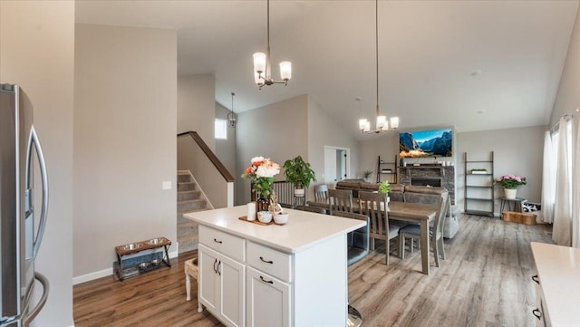 kitchen with freestanding refrigerator, a chandelier, a healthy amount of sunlight, and light wood finished floors