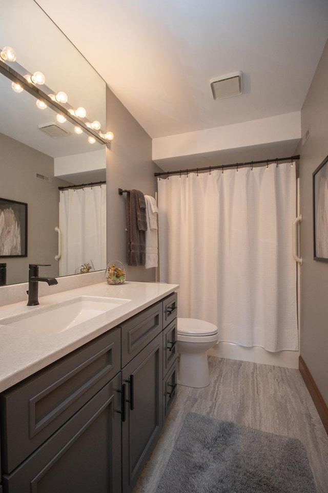 4360 France Ave S Unit 2, Edina, MN 55410 - bathroom featuring a shower with curtain, vanity, toilet, visible vents, and wood finished floors