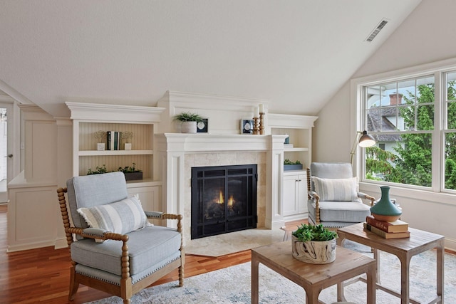 205 Mill St Unit S301, Excelsior, MN 55331 - living area featuring a fireplace, healthy amount of natural light, light wood-type flooring, lofted ceiling, and built in features