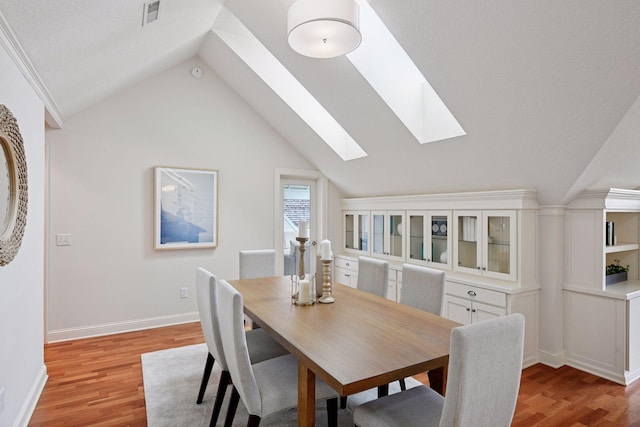 205 Mill St Unit S301, Excelsior, MN 55331 - dining area featuring light wood-style floors, vaulted ceiling, a skylight, and baseboards