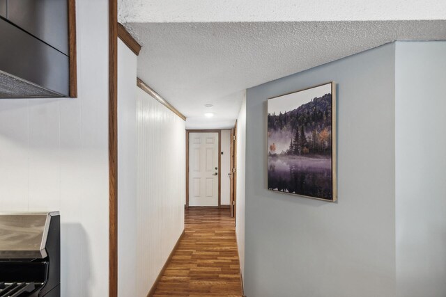 hallway featuring wood finished floors and a textured ceiling