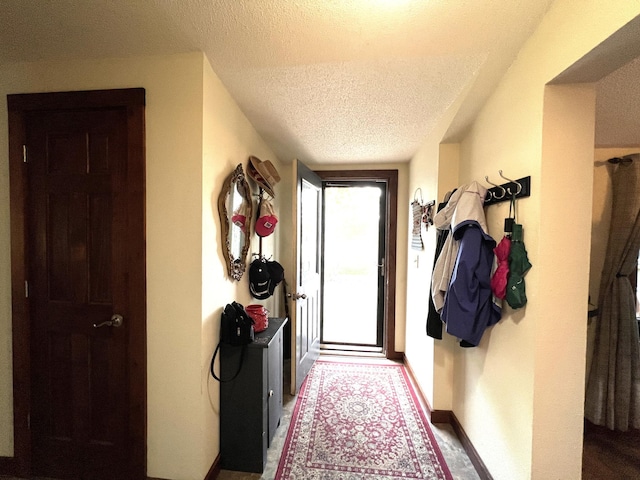 entryway with a textured ceiling and baseboards