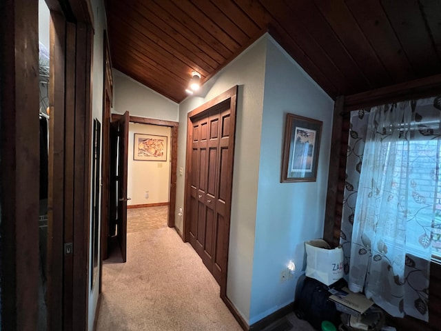 hallway with lofted ceiling, light colored carpet, wood ceiling, and baseboards