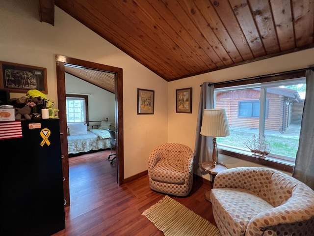 living area with vaulted ceiling, wood finished floors, baseboards, and wooden ceiling