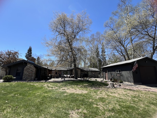 view of grassy yard with an outbuilding and a detached garage