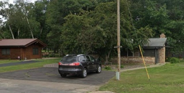 view of parking featuring asphalt driveway