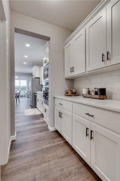 2505 Jaber Ave NE, Saint Michael, MN 55376 - bar with appliances with stainless steel finishes, light wood-style floors, recessed lighting, decorative backsplash, and baseboards