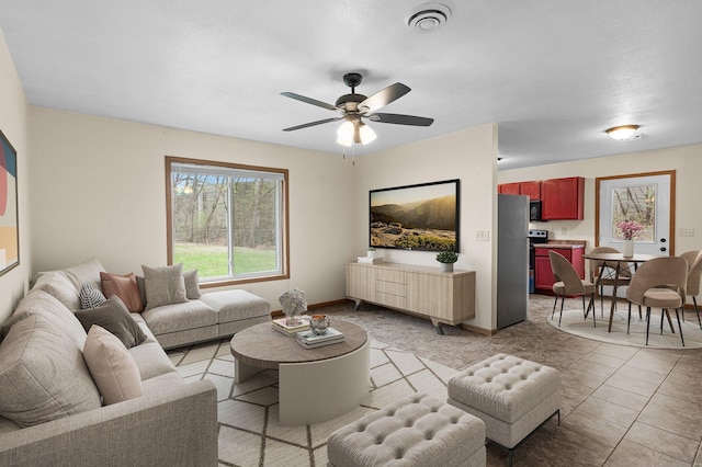 living area featuring a ceiling fan, visible vents, and baseboards