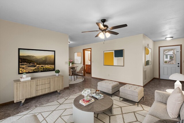 living room featuring baseboards and a ceiling fan