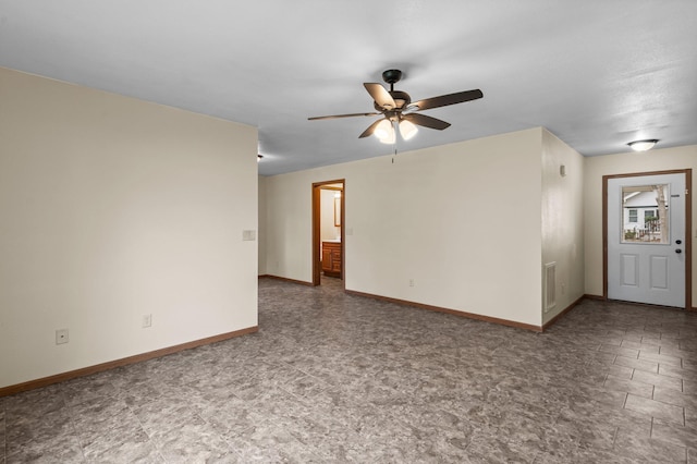 spare room featuring baseboards, visible vents, and ceiling fan