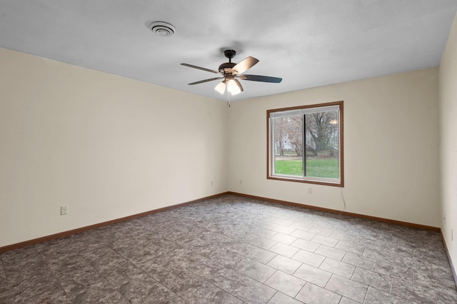 empty room featuring visible vents, ceiling fan, and baseboards