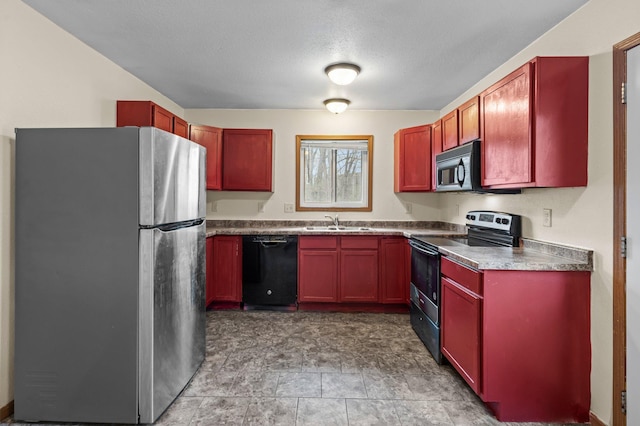 kitchen with black appliances, a textured ceiling, reddish brown cabinets, and a sink