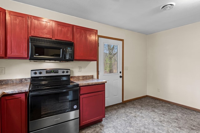 kitchen featuring stainless steel range with electric stovetop, black microwave, baseboards, dark countertops, and reddish brown cabinets