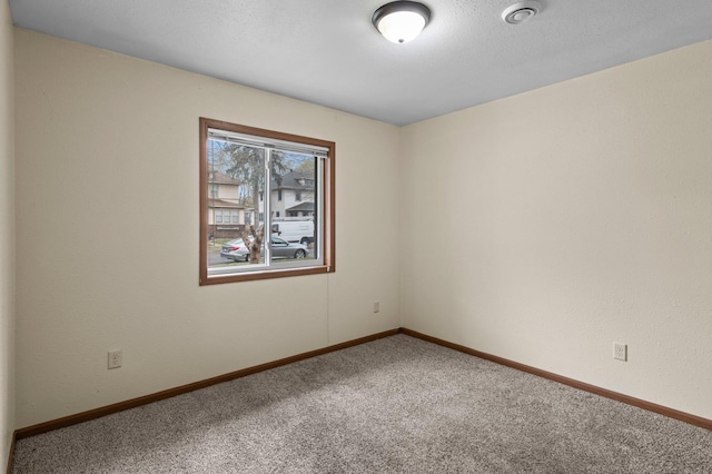 carpeted empty room with baseboards