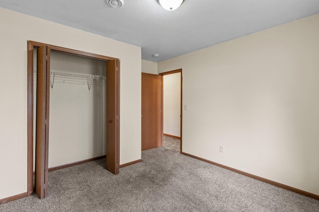 unfurnished bedroom with a closet, baseboards, and carpet floors